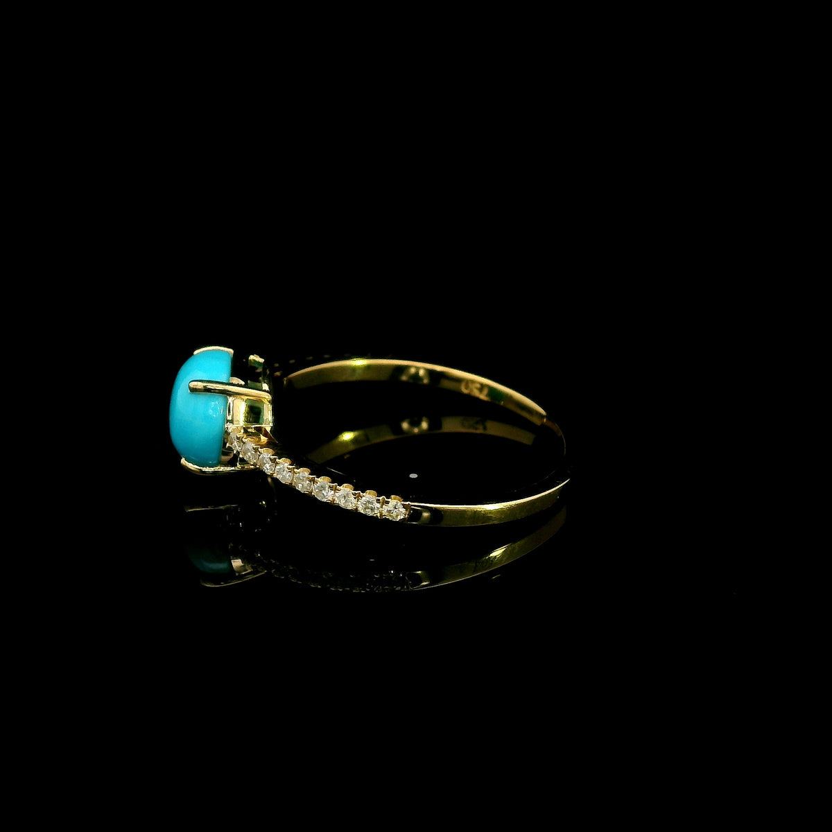 18K yellow gold turquoise and diamond ring featuring a round cabochon turquoise gemstone in a four-prong setting with round diamonds along the band.