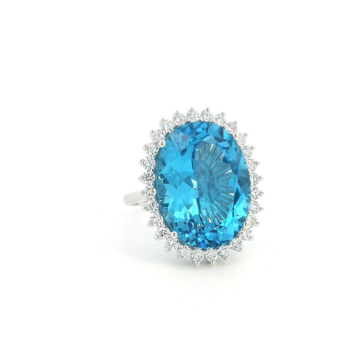Swiss Blue Topaz halo ring in 18K white gold with an oval blue gemstone surrounded by round diamonds.