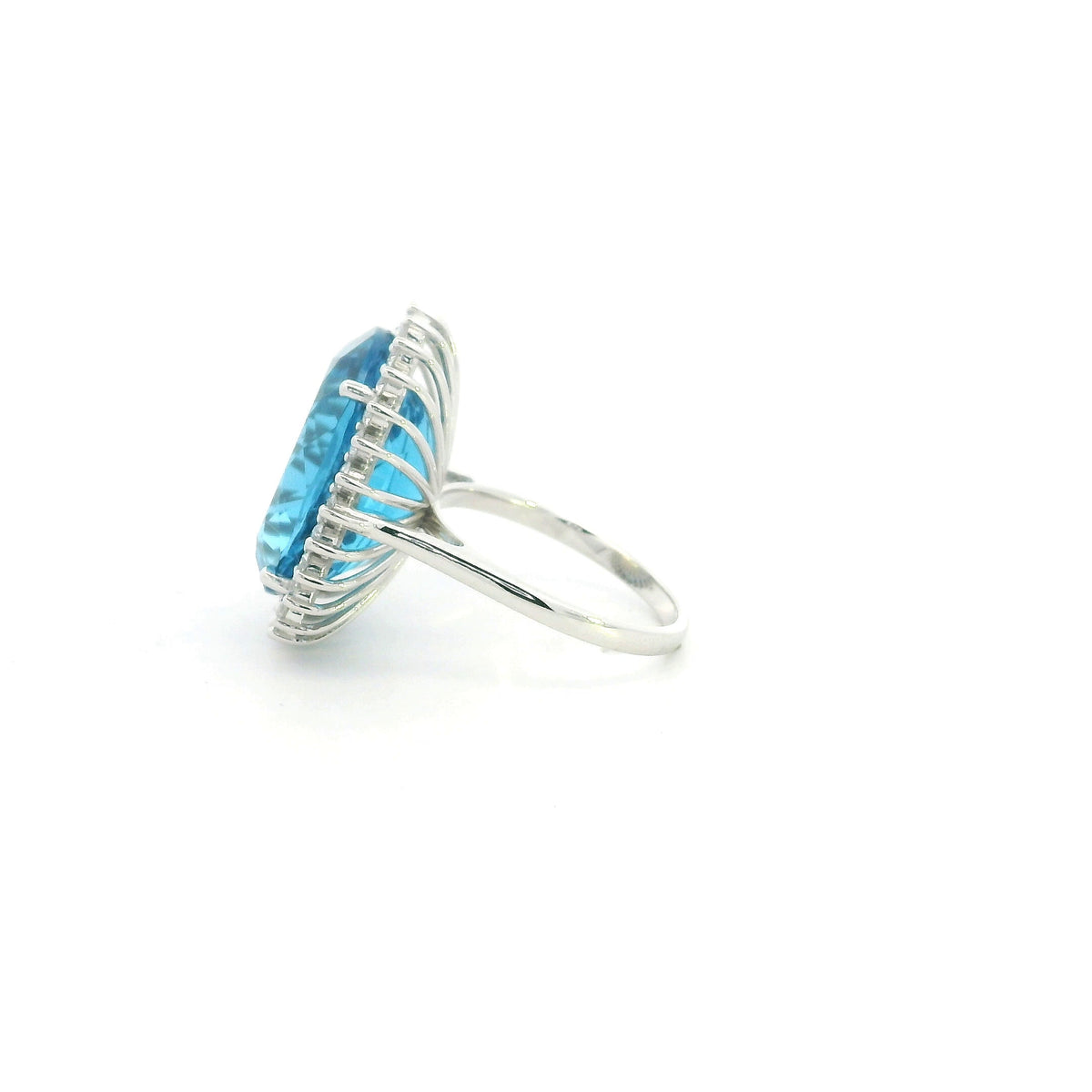Swiss Blue Topaz halo ring in 18K white gold with an oval blue gemstone surrounded by round diamonds.