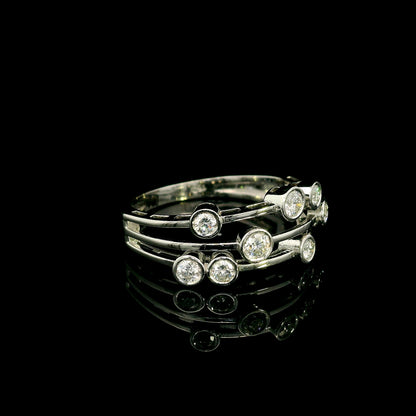Diamond bezel set multi-row ring in 18K white gold featuring asymmetrically arranged round diamonds across polished open bands.