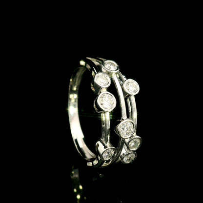 Diamond bezel set multi-row ring in 18K white gold featuring asymmetrically arranged round diamonds across polished open bands.