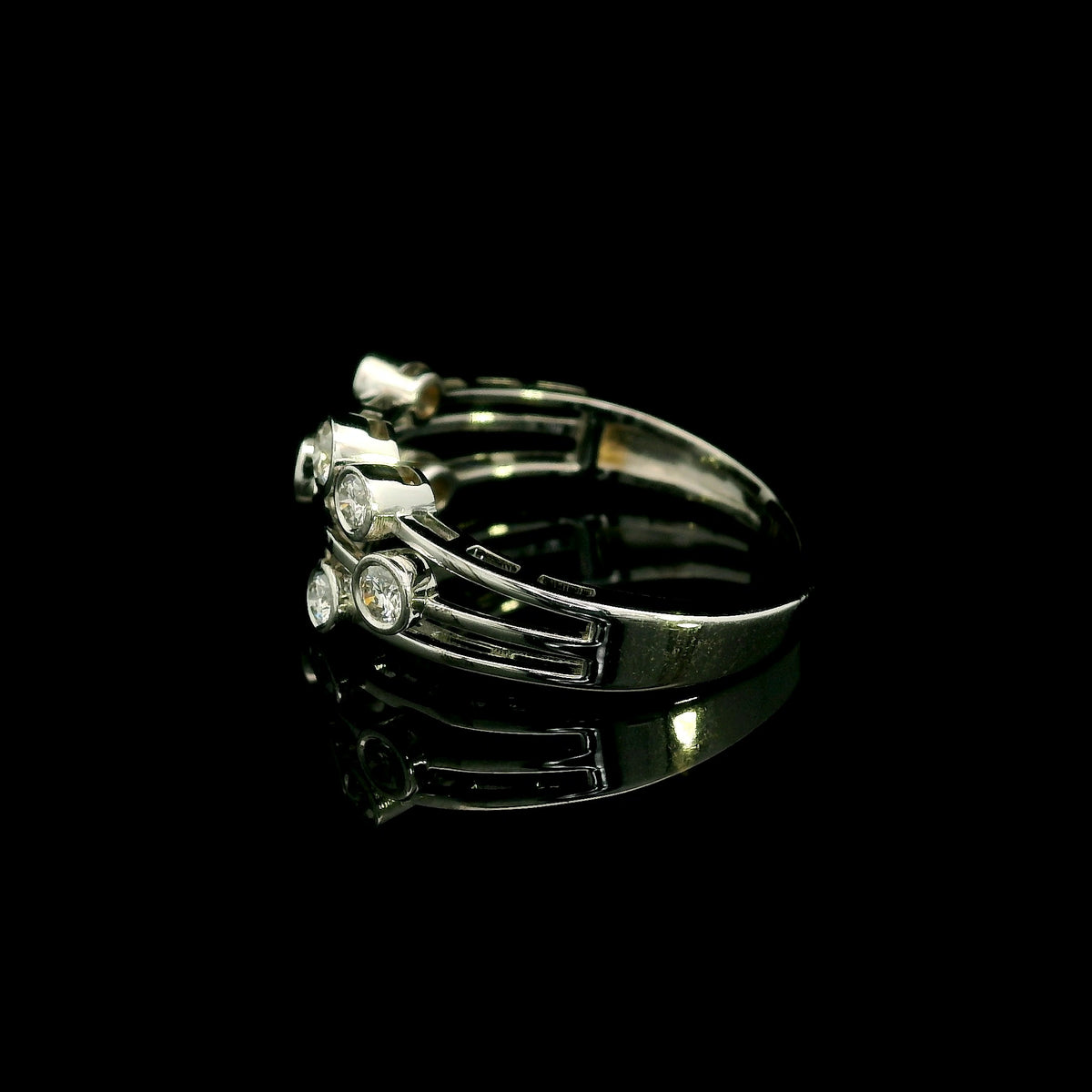 Diamond bezel set multi-row ring in 18K white gold featuring asymmetrically arranged round diamonds across polished open bands.