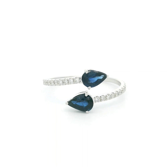 18K white gold blue sapphire Toi et Moi ring featuring two pear-shaped blue sapphires positioned in opposite directions with round diamonds along the open band.