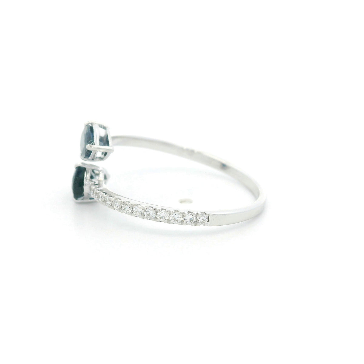 18K white gold blue sapphire Toi et Moi ring featuring two pear-shaped blue sapphires positioned in opposite directions with round diamonds along the open band.