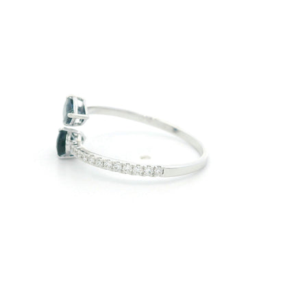 18K white gold blue sapphire Toi et Moi ring featuring two pear-shaped blue sapphires positioned in opposite directions with round diamonds along the open band.