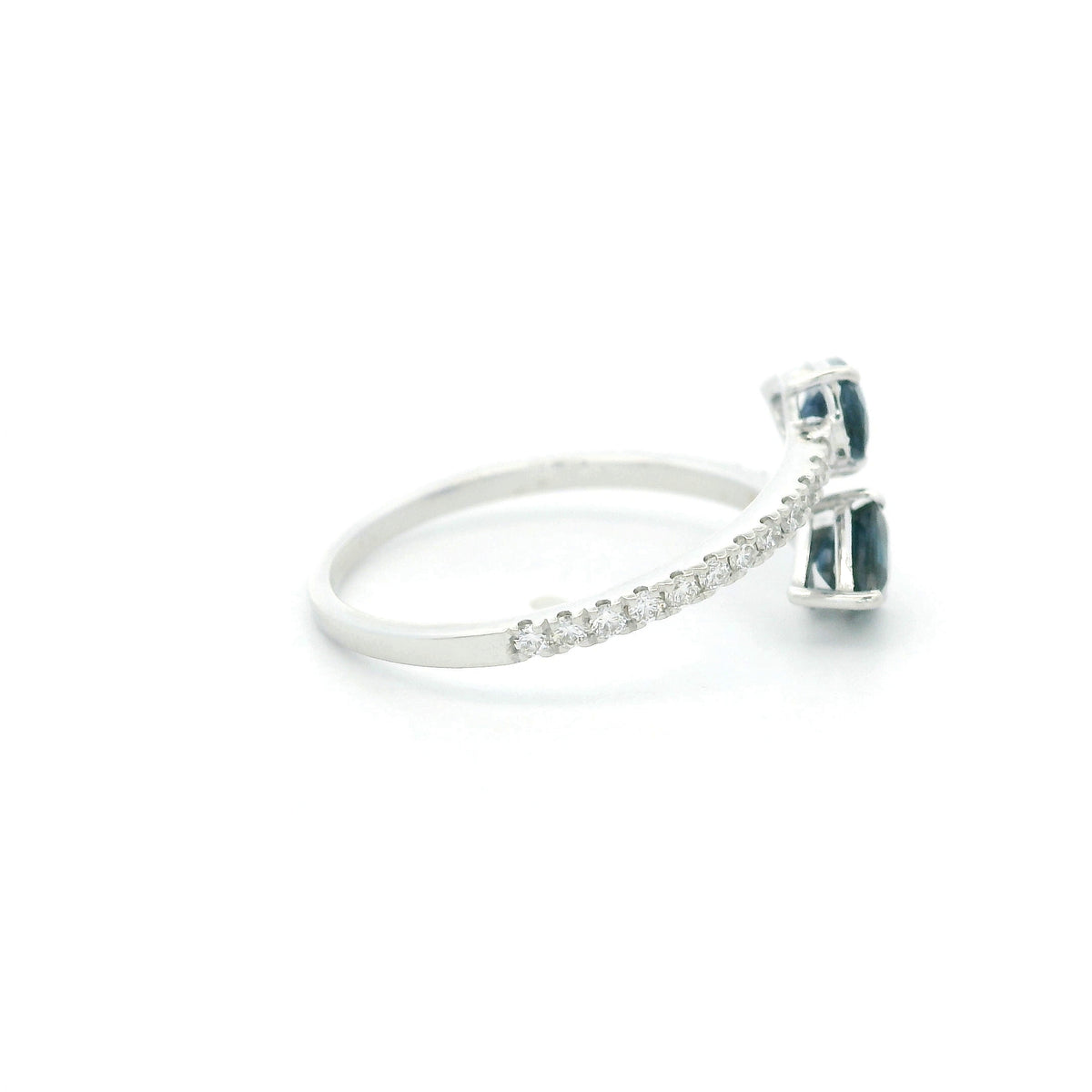 18K white gold blue sapphire Toi et Moi ring featuring two pear-shaped blue sapphires positioned in opposite directions with round diamonds along the open band.