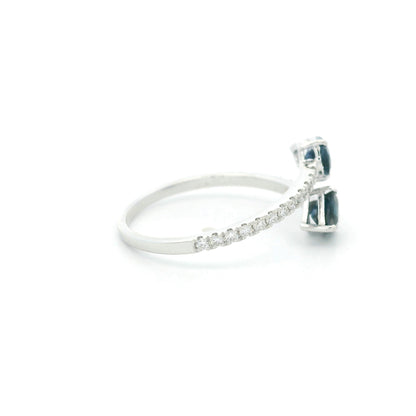 18K white gold blue sapphire Toi et Moi ring featuring two pear-shaped blue sapphires positioned in opposite directions with round diamonds along the open band.