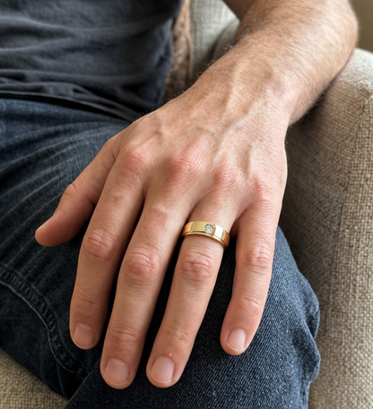 Men's 18K yellow gold band featuring a single round flush-set diamond, polished finish and fine grooved detailing.