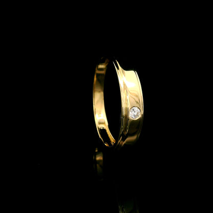Men's 18K yellow gold band featuring a single round flush-set diamond, polished finish and fine grooved detailing.