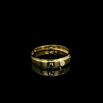Men's 18K yellow gold band featuring a single round flush-set diamond, polished finish and fine grooved detailing.