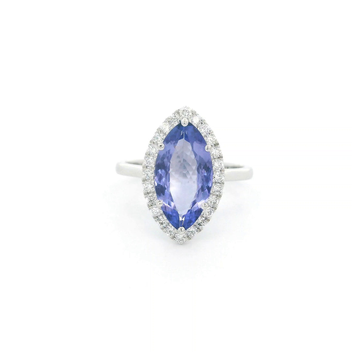 Marquise tanzanite and diamond halo ring in 18K white gold featuring a blue-violet gemstone surrounded by round diamonds.