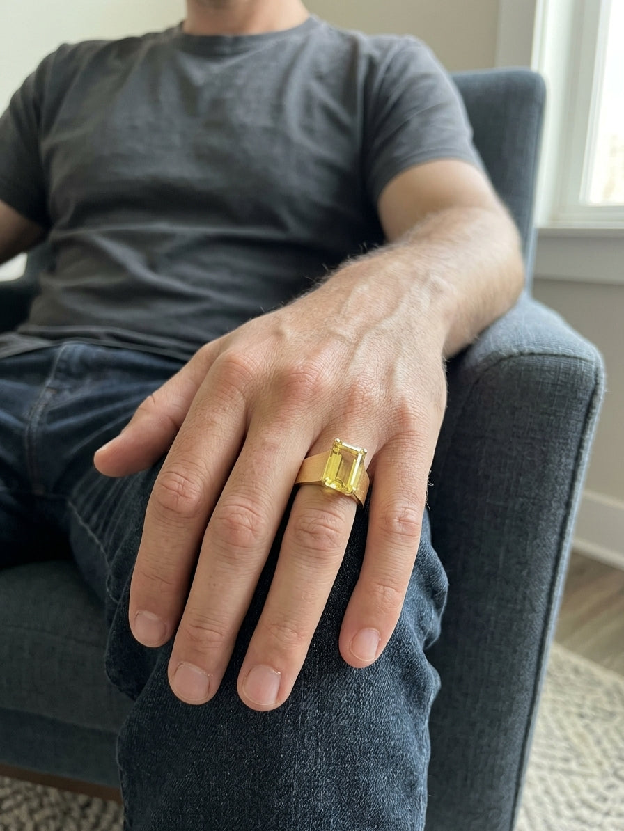 Men's yellow beryl ring in 18K yellow gold featuring a rectangular emerald-cut gemstone in a four-prong setting and a wide gold band.