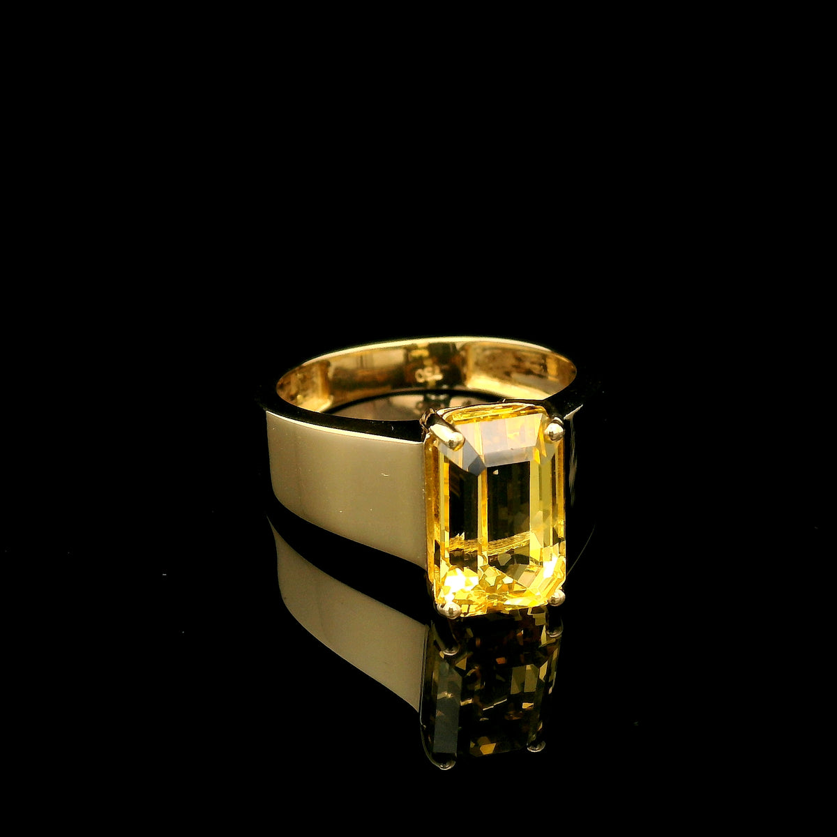 Men's yellow beryl ring in 18K yellow gold featuring a rectangular emerald-cut gemstone in a four-prong setting and a wide gold band.