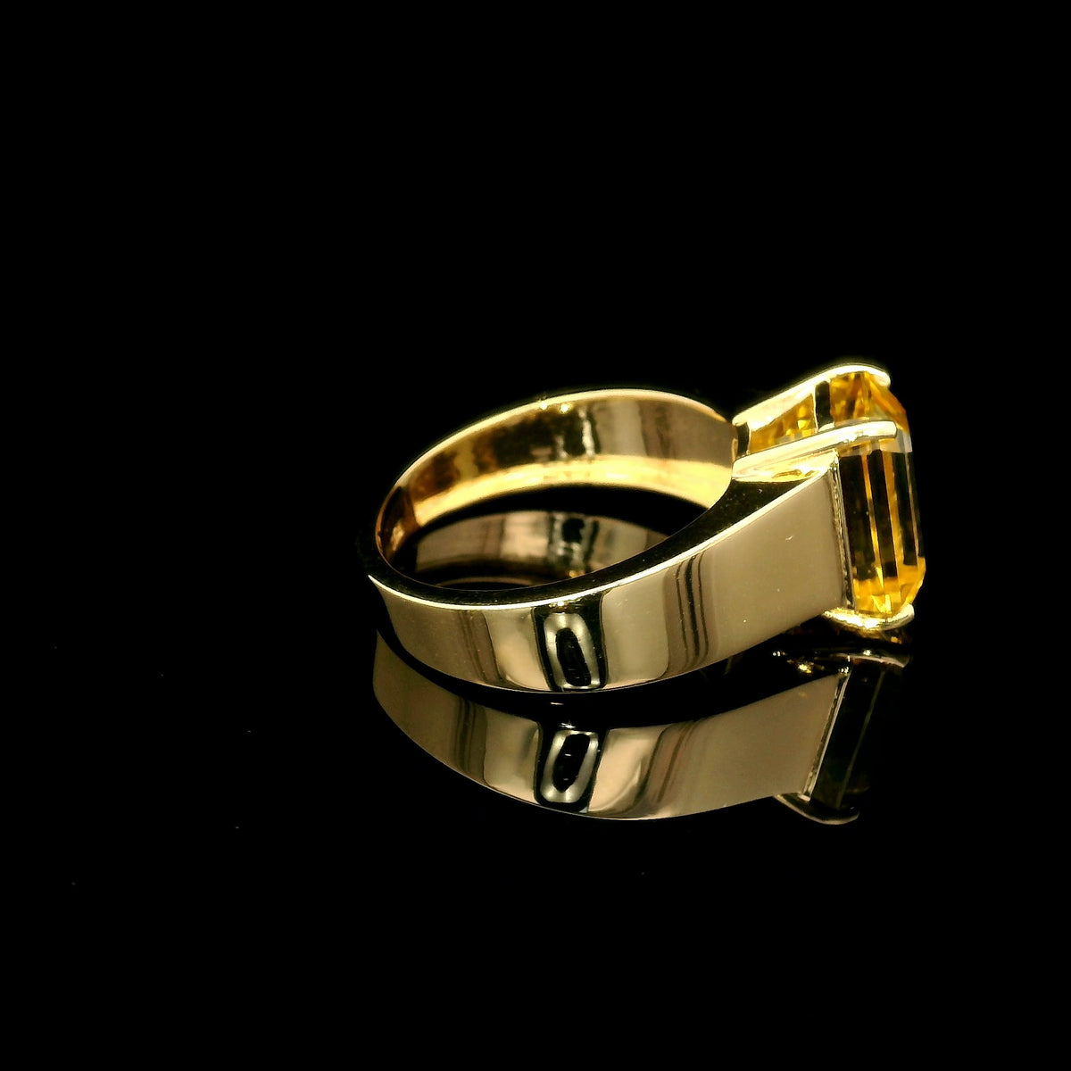 Men's yellow beryl ring in 18K yellow gold featuring a rectangular emerald-cut gemstone in a four-prong setting and a wide gold band.