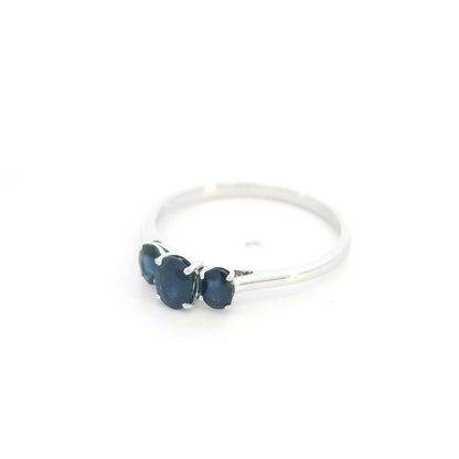 18K white gold ring featuring three oval blue sapphires, with a larger centre gemstone and two smaller side stones on a slim polished band.