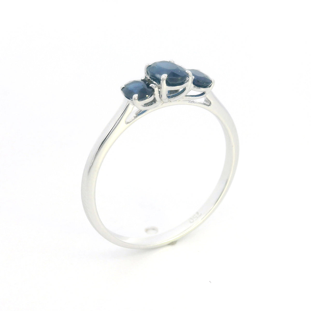 18K white gold ring featuring three oval blue sapphires, with a larger centre gemstone and two smaller side stones on a slim polished band.