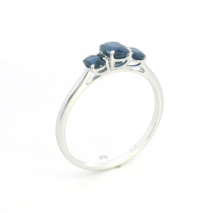 18K white gold ring featuring three oval blue sapphires, with a larger centre gemstone and two smaller side stones on a slim polished band.