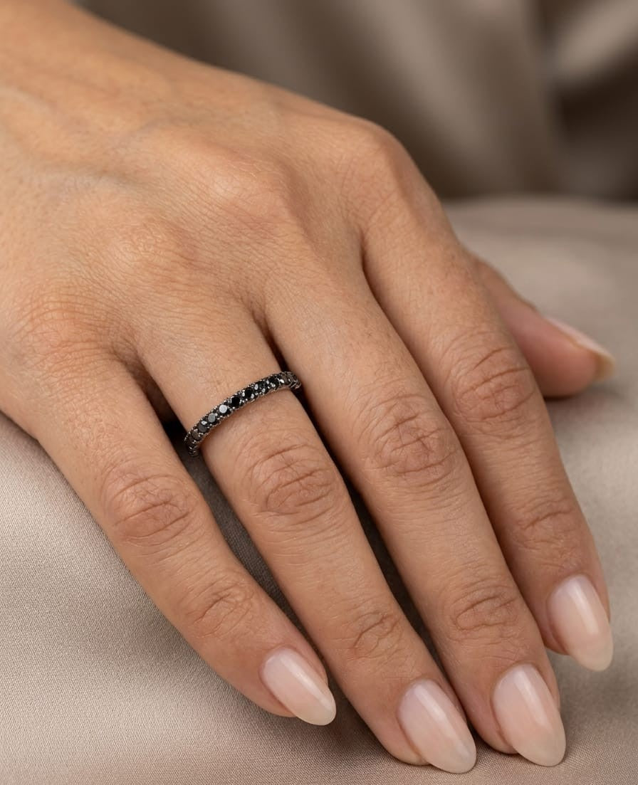 18K white gold half eternity ring featuring a single row of round black diamonds set across the front of a slim, polished band.