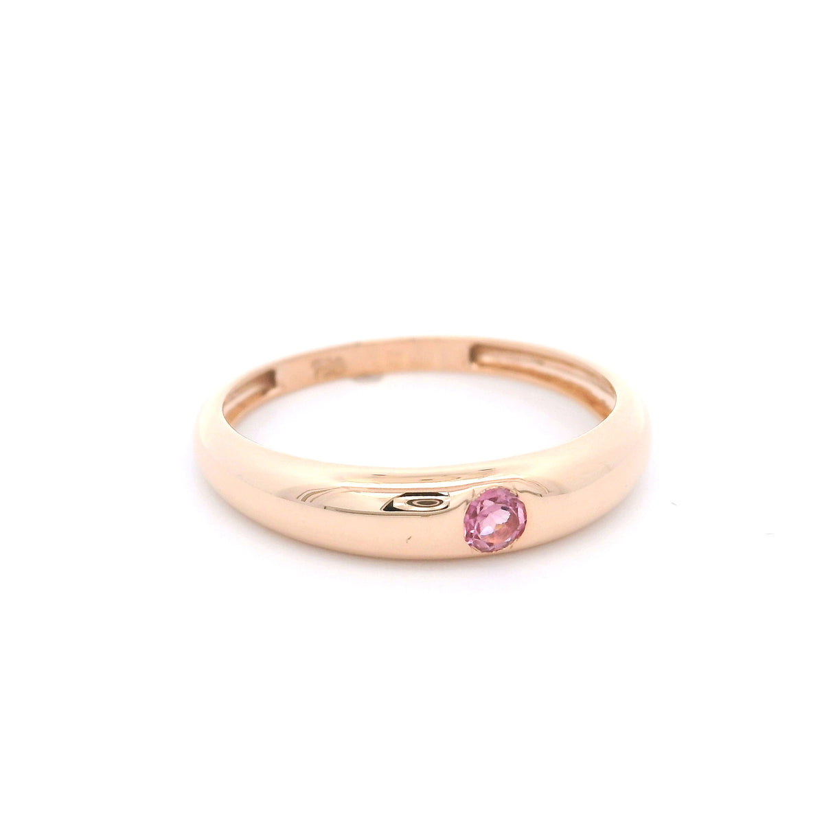 Pink tourmaline ring in 18K rose gold featuring a small round pink gemstone set into a smooth, polished, rounded gold band.