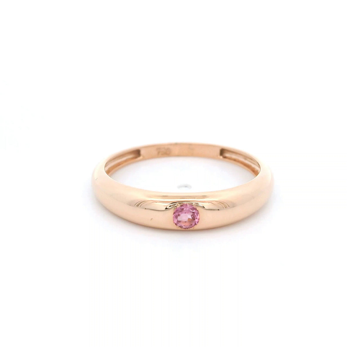 Pink tourmaline ring in 18K rose gold featuring a small round pink gemstone set into a smooth, polished, rounded gold band.