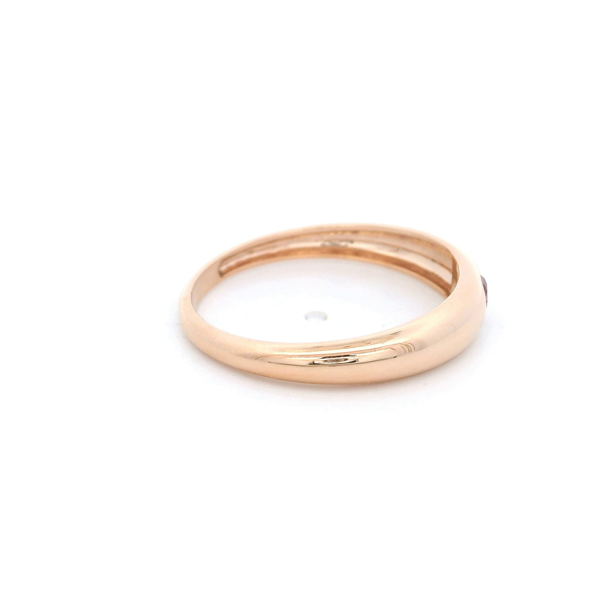Pink tourmaline ring in 18K rose gold featuring a small round pink gemstone set into a smooth, polished, rounded gold band.