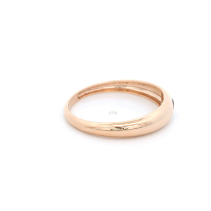 Pink tourmaline ring in 18K rose gold featuring a small round pink gemstone set into a smooth, polished, rounded gold band.