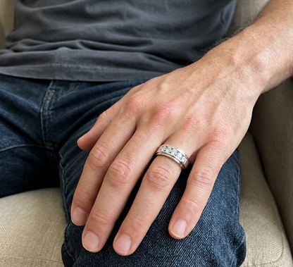 Men's 18K white gold band with five round diamonds in a channel-style setting framed by broad polished gold edges.