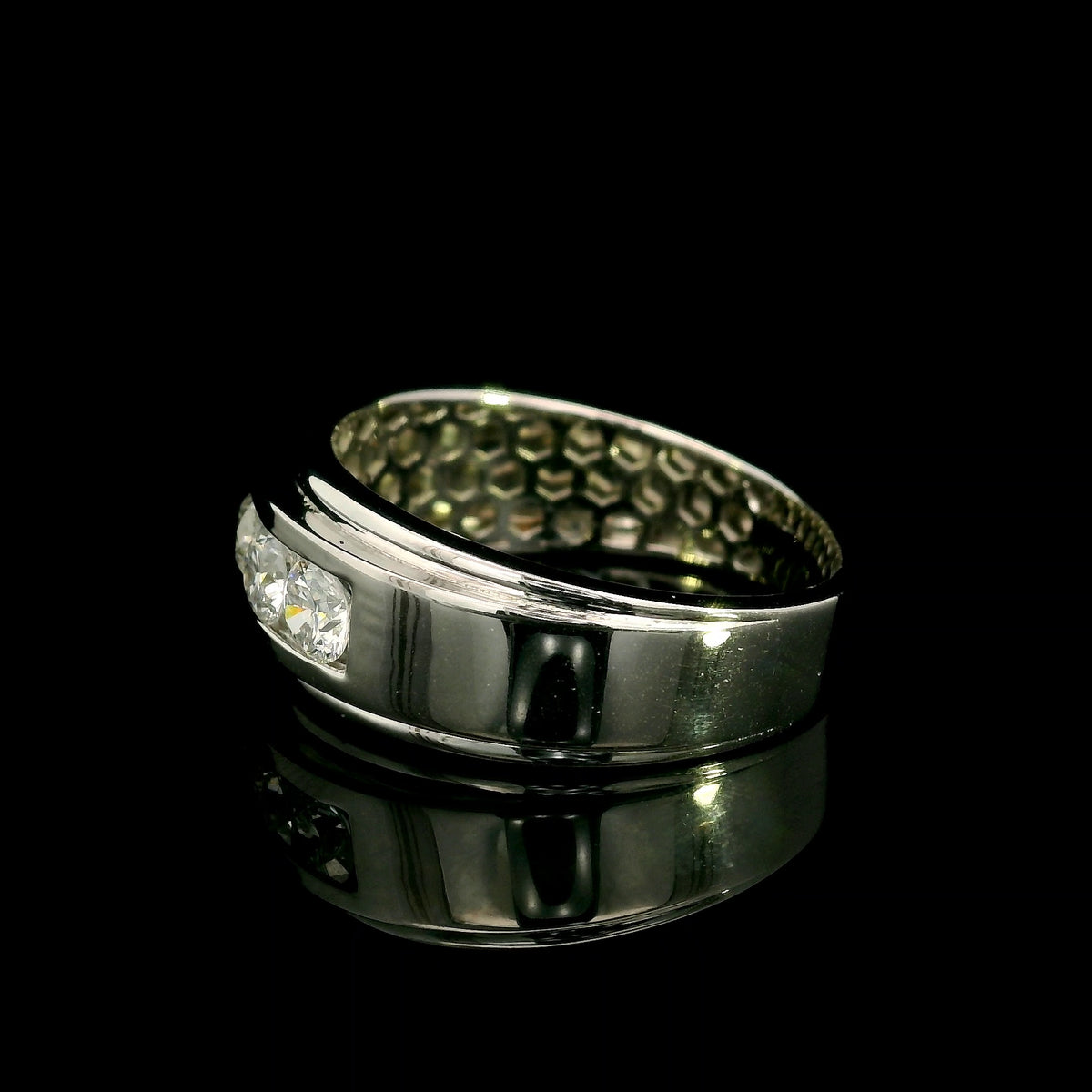 Men's 18K white gold band with five round diamonds in a channel-style setting framed by broad polished gold edges.
