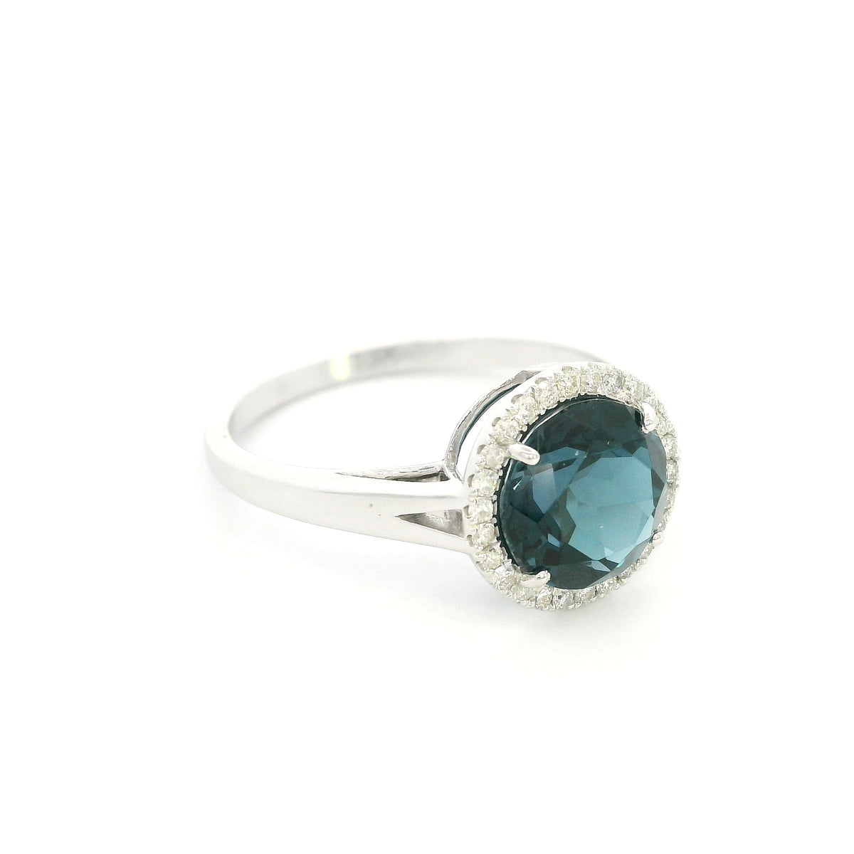 18K white gold ring with a deep blue London blue topaz surrounded by round diamonds and a split-shoulder band.