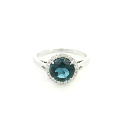 18K white gold ring with a deep blue London blue topaz surrounded by round diamonds and a split-shoulder band.