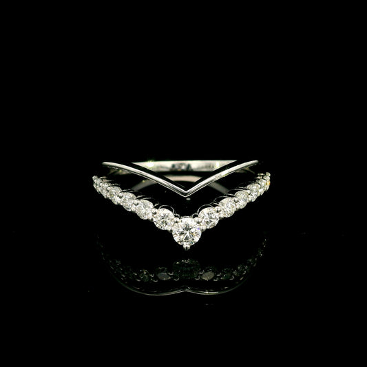 V shaped diamond ring in 18K white gold featuring a polished chevron band above a diamond-set V with a 0.13 carat round diamond at the pointed centre.