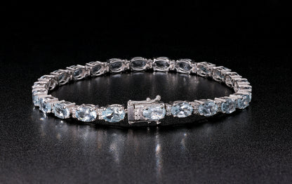 Aquamarine tennis bracelet in 18K white gold featuring oval blue aquamarine gemstones and sparkling diamond accents.