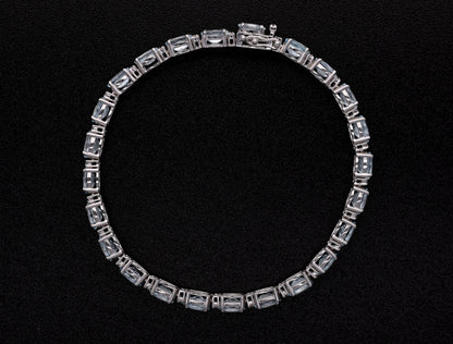 Aquamarine tennis bracelet in 18K white gold featuring oval blue aquamarine gemstones and sparkling diamond accents.