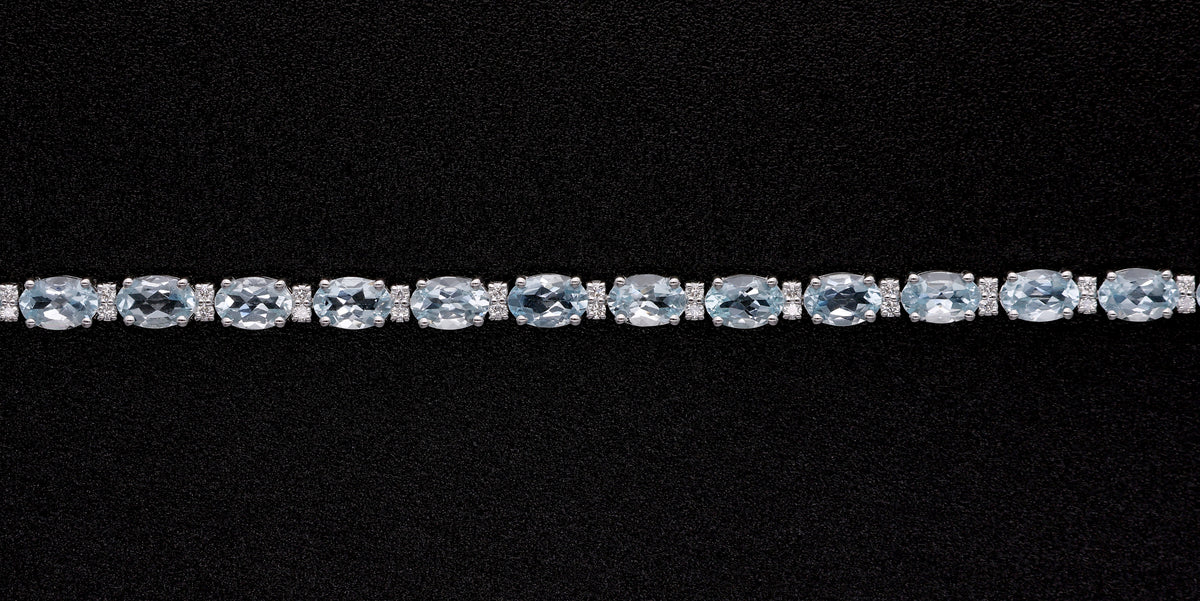 Aquamarine tennis bracelet in 18K white gold featuring oval blue aquamarine gemstones and sparkling diamond accents.
