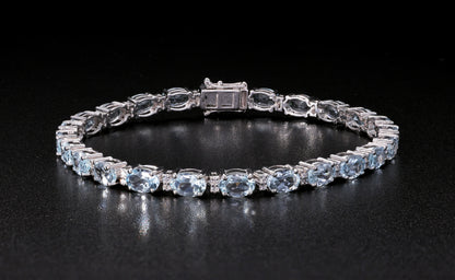 Aquamarine tennis bracelet in 18K white gold featuring oval blue aquamarine gemstones and sparkling diamond accents.