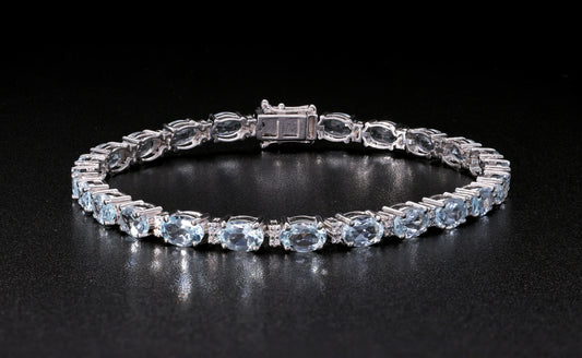 Aquamarine tennis bracelet in 18K white gold featuring oval blue aquamarine gemstones and sparkling diamond accents.