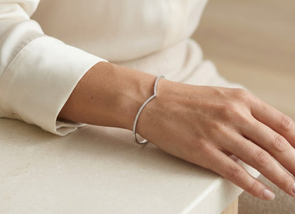 18K white gold V-shaped diamond bangle with round brilliant diamonds across the front