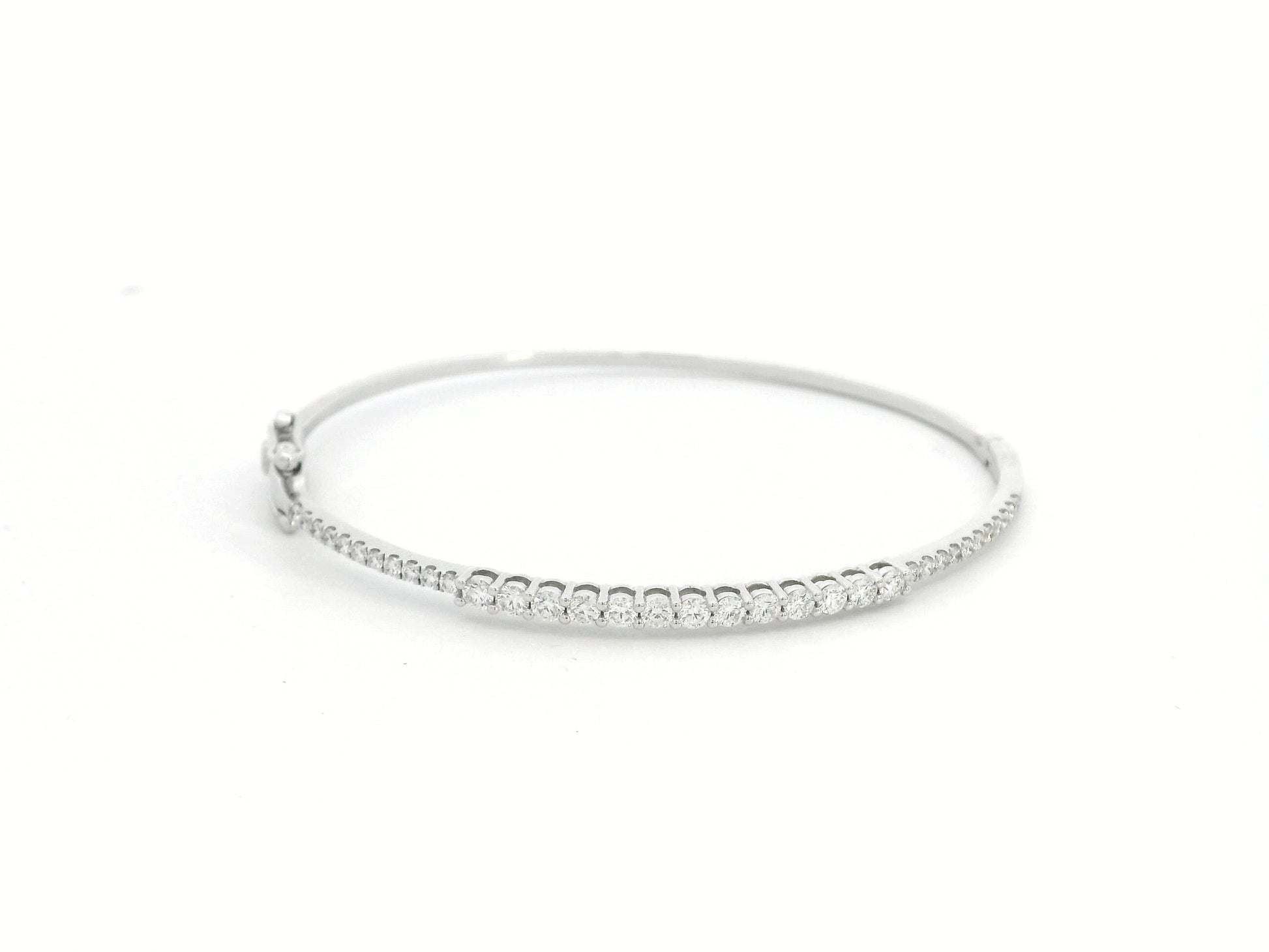 Minimalist 18K gold bangle with 1.03 carat dual-size round-cut diamonds, polished finish