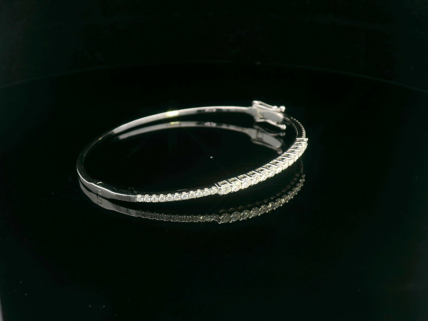 Minimalist 18K gold bangle with 1.03 carat dual-size round-cut diamonds, polished finish