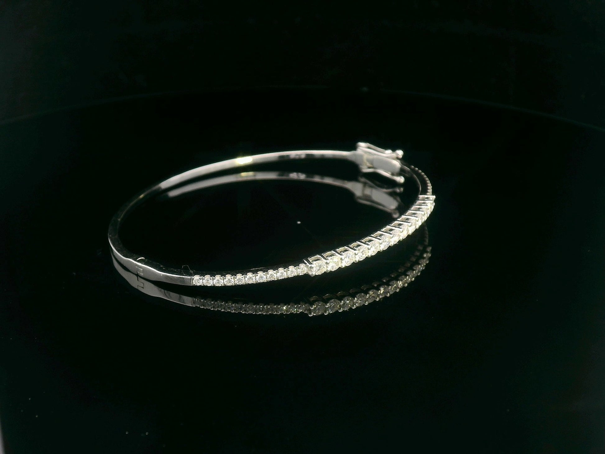 Minimalist 18K gold bangle with 1.03 carat dual-size round-cut diamonds, polished finish