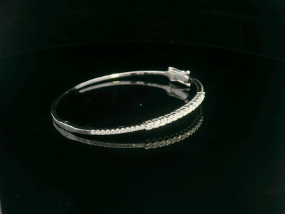 Minimalist 18K gold bangle with 1.03 carat dual-size round-cut diamonds, polished finish