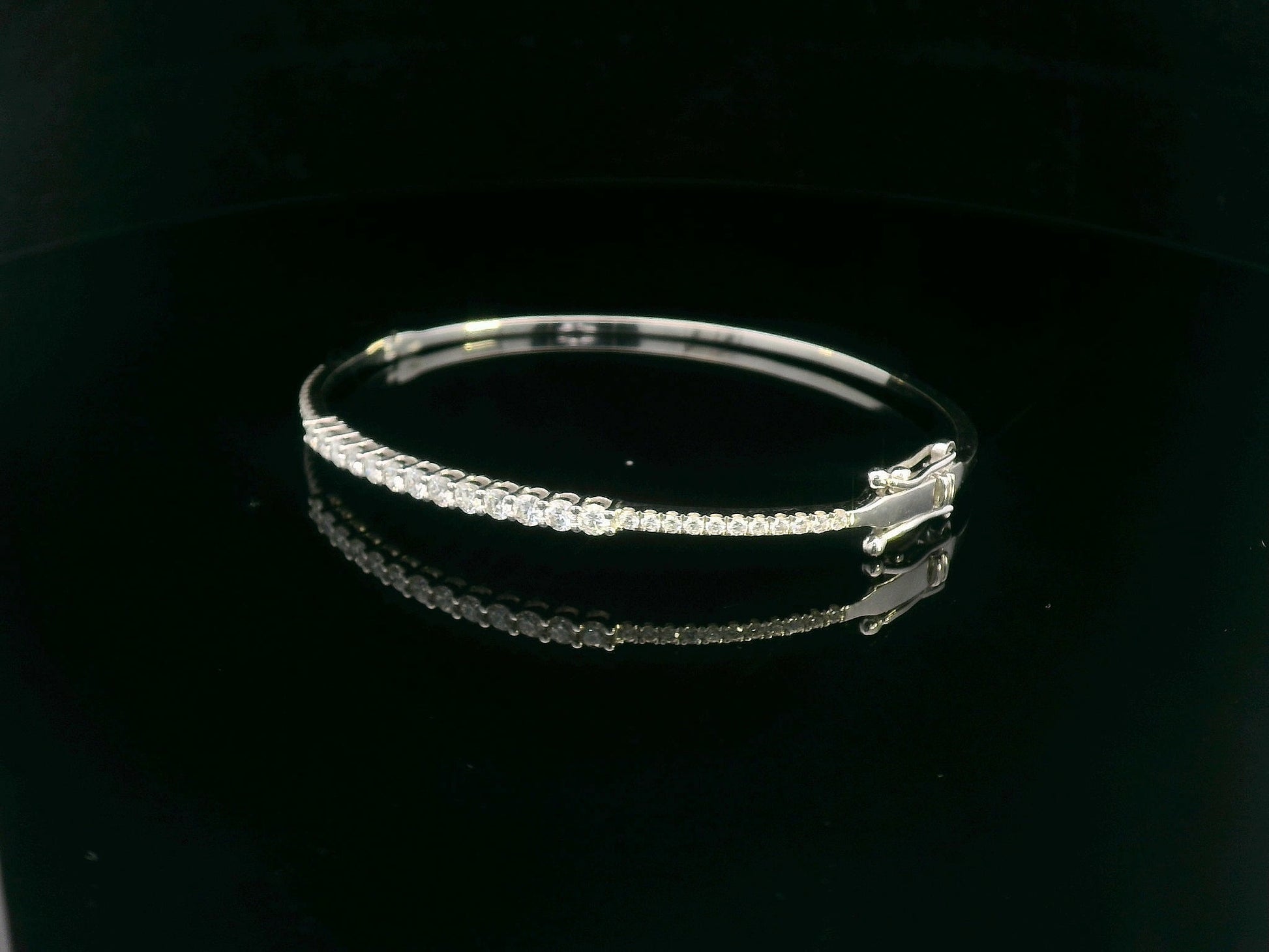 Minimalist 18K gold bangle with 1.03 carat dual-size round-cut diamonds, polished finish
