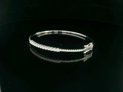 Minimalist 18K gold bangle with 1.03 carat dual-size round-cut diamonds, polished finish