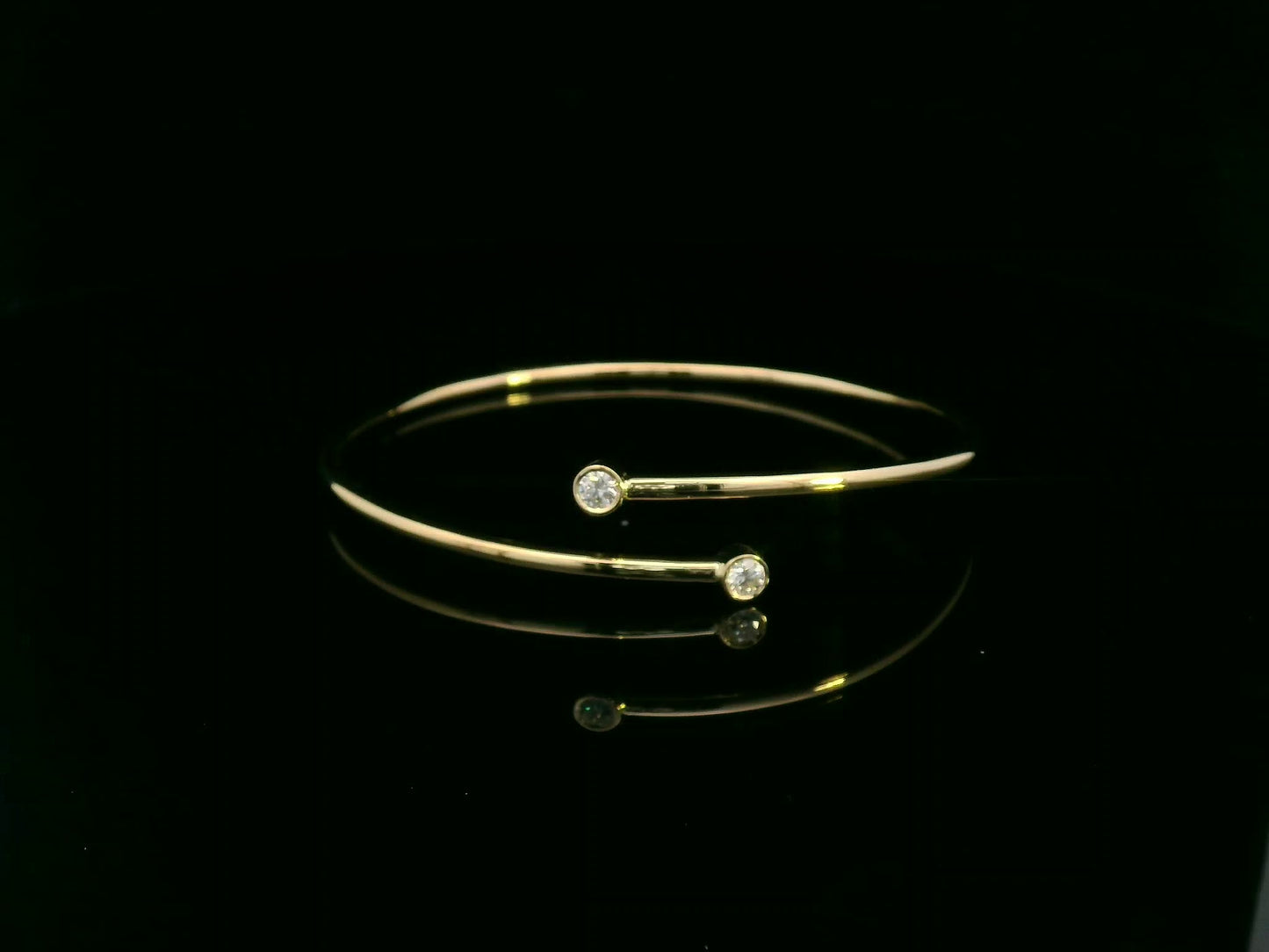 Diamond open cuff bangle bracelet in 18K yellow gold with bezel set diamonds by Emirates Diamonds