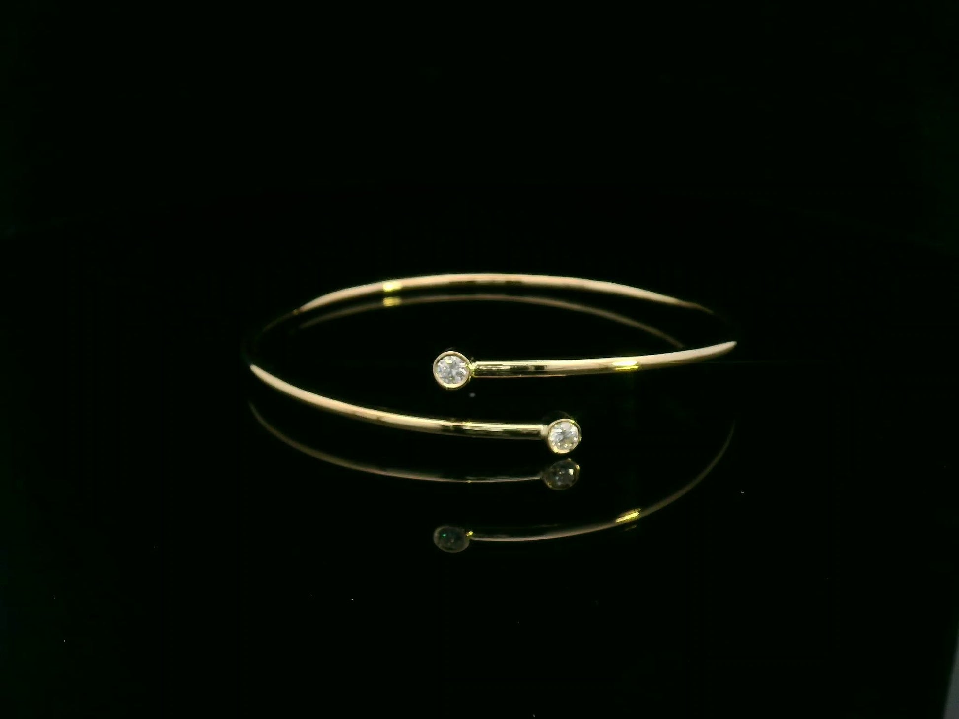 Diamond open cuff bangle bracelet in 18K yellow gold with bezel set diamonds by Emirates Diamonds