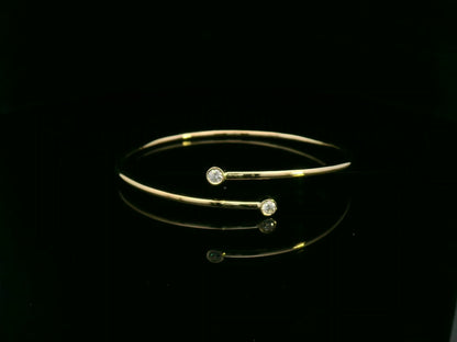 Diamond open cuff bangle bracelet in 18K yellow gold with bezel set diamonds by Emirates Diamonds