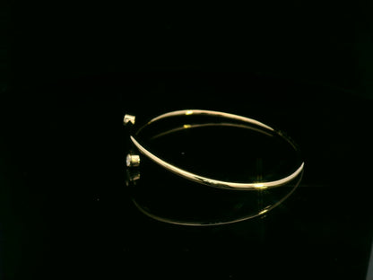 Diamond open cuff bangle bracelet in 18K yellow gold with bezel set diamonds by Emirates Diamonds