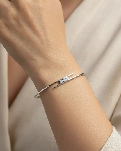 0.25 carat diamond bypass bangle in 18K white gold by Emirates Diamonds featuring floating round brilliant diamonds.
