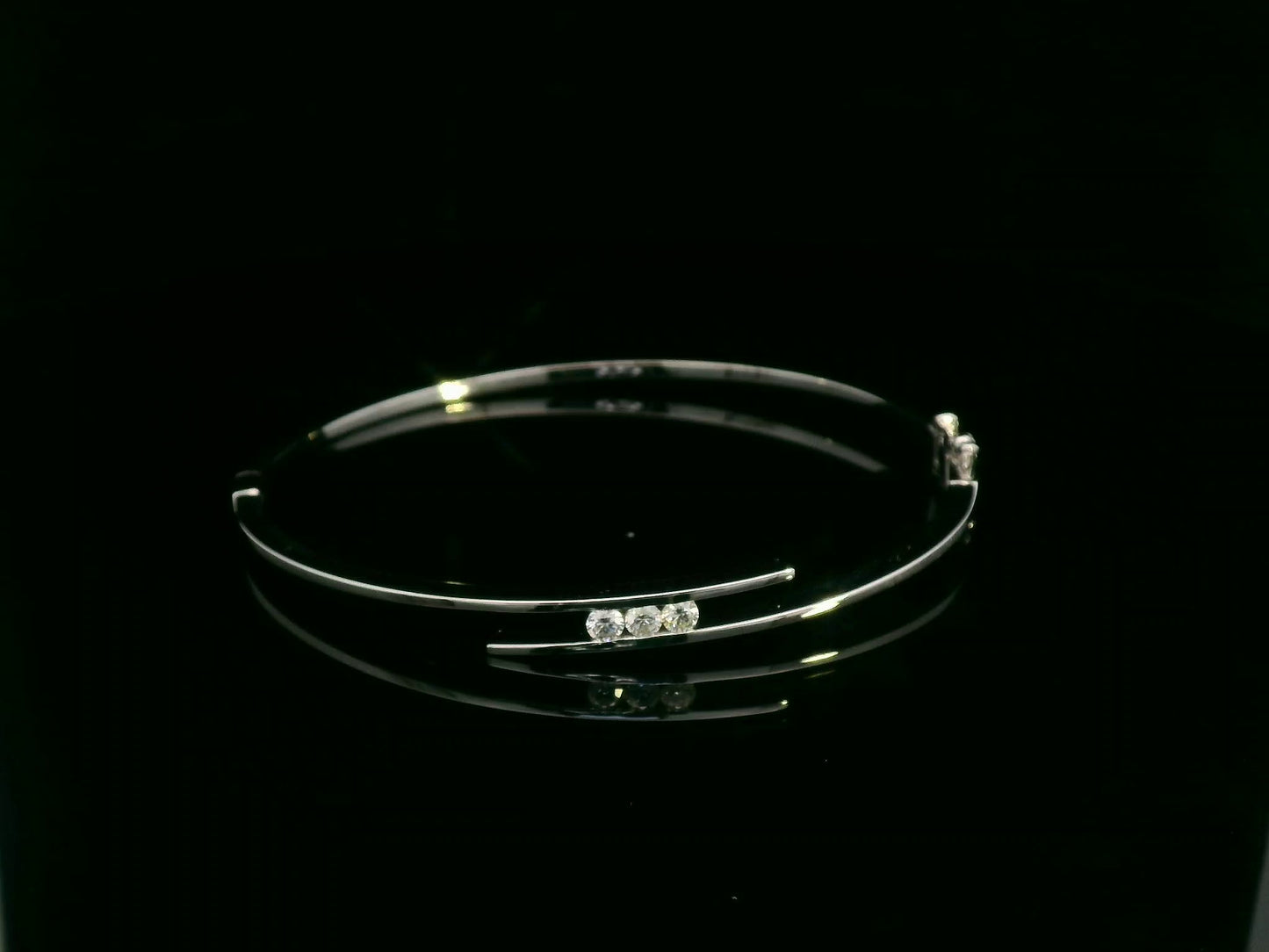 0.25 carat diamond bypass bangle in 18K white gold by Emirates Diamonds featuring floating round brilliant diamonds.