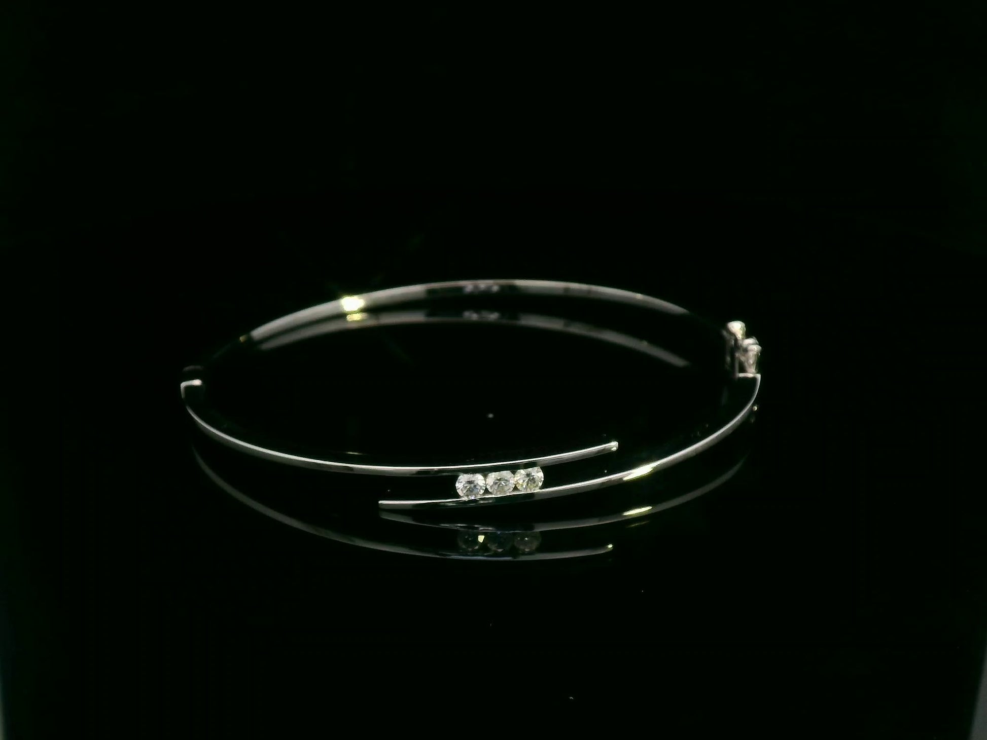 0.25 carat diamond bypass bangle in 18K white gold by Emirates Diamonds featuring floating round brilliant diamonds.